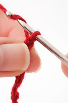 A human hand crocheting. All isolated on white background.