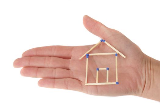 A human hand protecting a stylized house out of matchsticks. All isolated on white background.