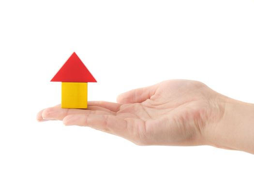 A human hand holding a stylized house out of colored blocks. All isolated on white background.