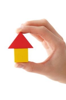 A human hand holding a stylized house out of colored blocks. All isolated on white background.