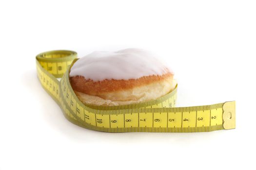 A jelly donuts with measuring tape. All isolated on white background.
** Note: Shallow depth of field.