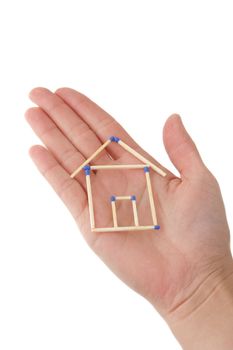 A human hand protecting a stylized house out of matchsticks. All isolated on white background.