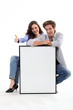 Couple crouching by empty frame