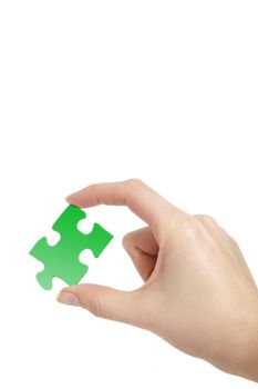 A person holding a green piece of a puzzle in his hand. All on white background.