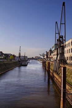 Typical industrial harbor scene in front of a blue sky.