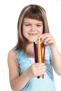 A young girl choosing a colorful crayon. All isolated on white background.
