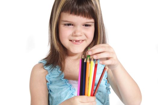 A young girl choosing a colorful crayon. All isolated on white background.