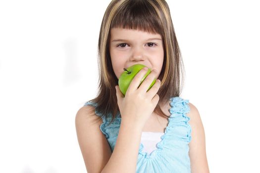 A young girl eating a green apple. All isolated on white background.