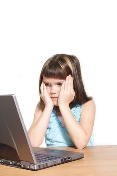 A young girl sitting in front of a broken notebook computer. All isolated on white background.