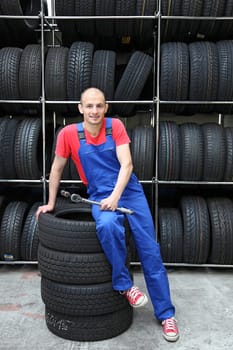 A mechanic is taking a small break in a tire workshop.