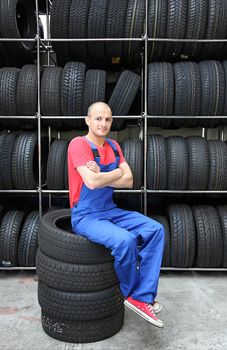 A mechanic is taking a small break in a tire workshop.