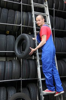 A motivated worker in a tire workshop restocking the goods.