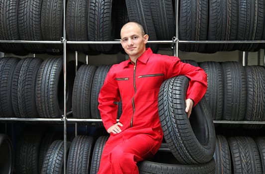 A motivated worker in a workshop holding a tire.