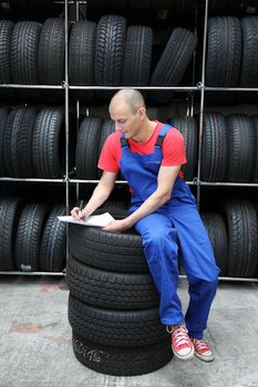 A worker takes inventory in a tire workshop.