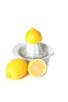 A lemon squeezer and lemons. All isolated on white background. ** Note: Shallow depth of field.
