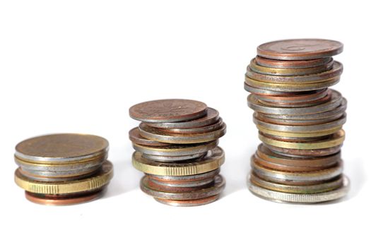 Three piles of coins in ascending positions. All isolated on white background.