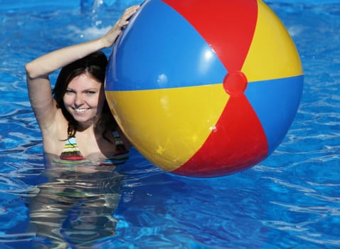 A very attractive young woman having fun in the swimming pool.