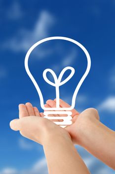 Human hands holding a stylized bulb in front of a bright blue sky.