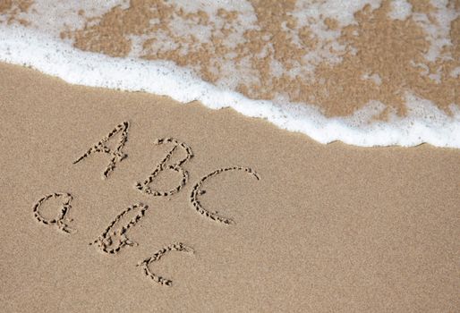 Writings in the sand on the beach symbolizing a, b and c.