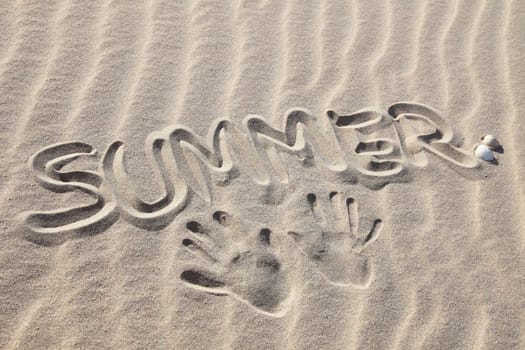 Writings in the sand on the beach symbolizing summer holiday.