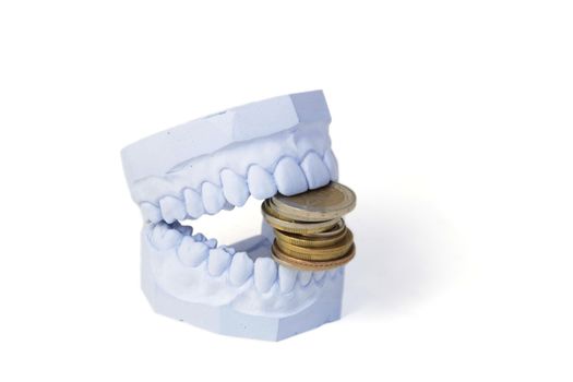 A set of teeth with some money. All isolated on white background.