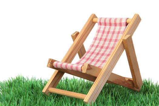 A standard deck chair on a green meadow. All isolated on white background.