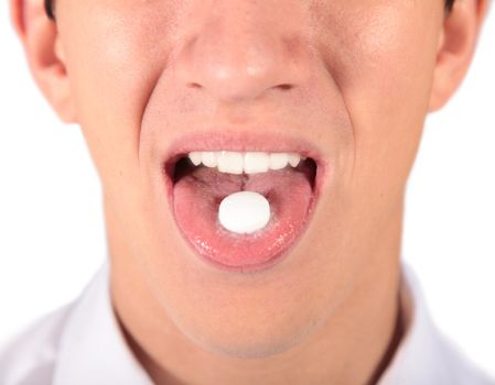 A young man taking a pill. All isolated on white background.