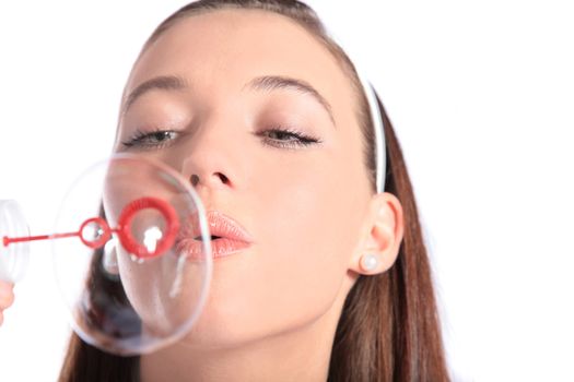 An attractive young woman blowing bubbles. All isolated on white background.