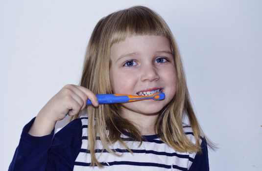 little girl is brushing her tooth