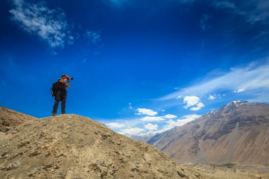 Photographer taking photos in Himalayas mountains. Spiti valley, Himachal Pradesh, India