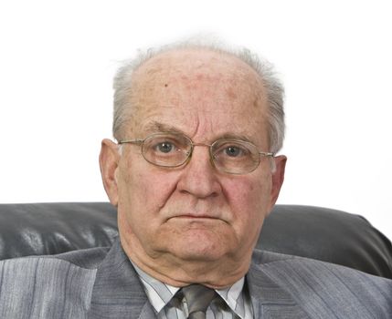 Portrait of a senior man with glasses sitting in an armchair 