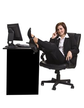 Relaxed businesswoman on the mobile phone at her office desk.