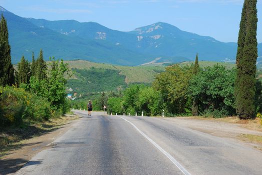 The lonely traveller. Mountain road to city