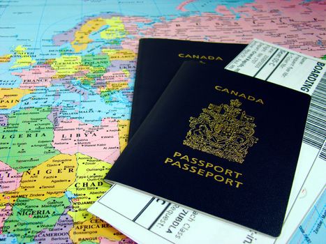 Canadian passports and boarding passes against map of the world.