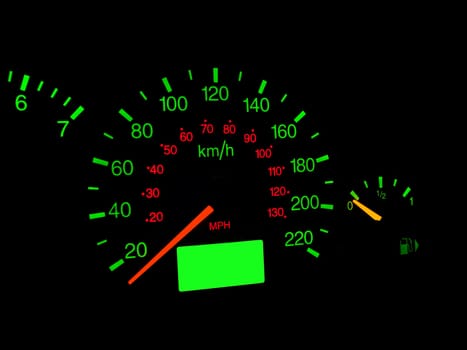 Close up of car dashboard gauges at night.