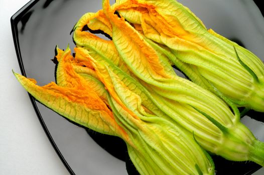 Zucchini flowers on black plate