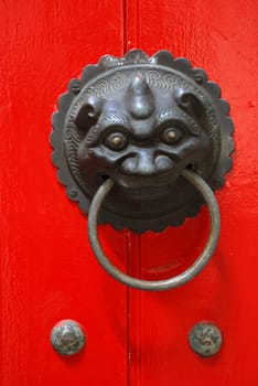 Brass knocker attached to the red door in an ancient building at chinese garden Singapore