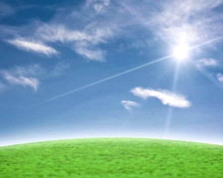 Blue sky and gree slope with a beautiful sun flare background.