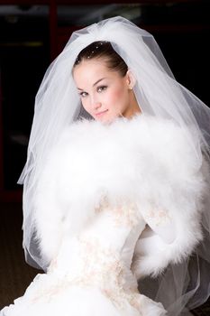 a beautiful bride smiles and covers with a cape