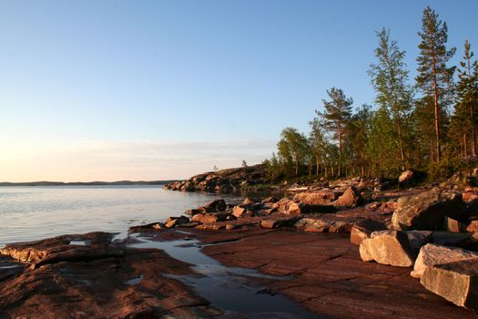 summer sunrise with forest, water and rocks
