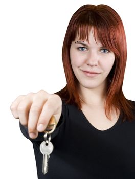Cute smiling redhead girl holding keys towards the camera.