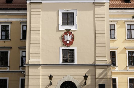 Polish eagle on coat of arms. Front of a traditional polish building.