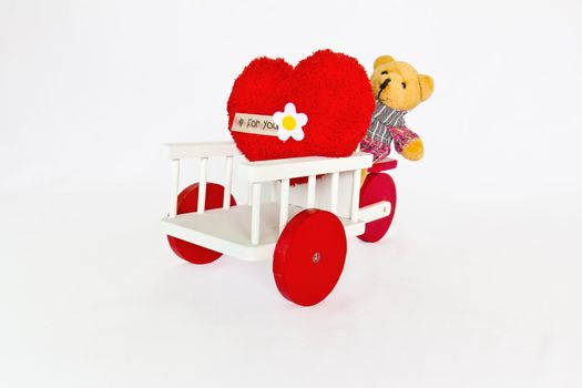 Red heart and bear on a tricycle.