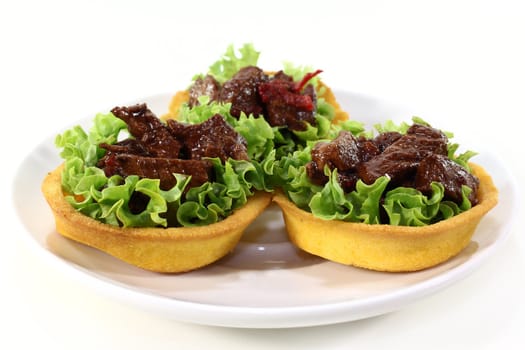 Corn cakes with beef salad on a white background