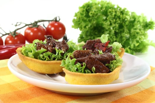 Corn cakes with beef salad on a white background