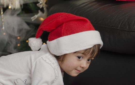 Baby with Christmas Hat playing indoor, Italy
