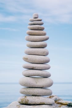 Balancing white pebbles each other on a sky background