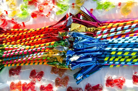 Table loaded with multicolored candies sold in outdoor fair.