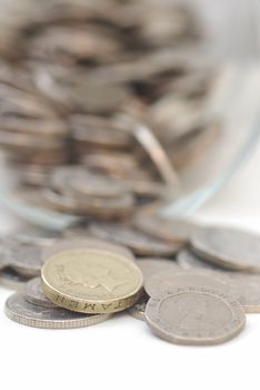 Spilled Coins from Glass Jar, focus on �1 coin. Sterling.