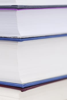 Corner of four books stacked. Copy space, focus on top left pages.